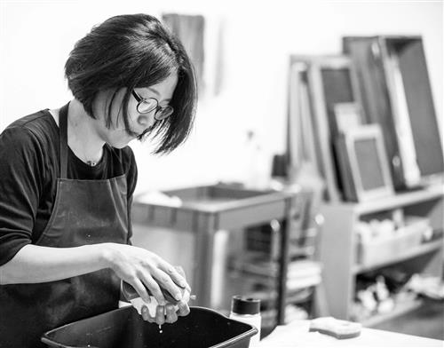 black and white photo of woman in an art studio